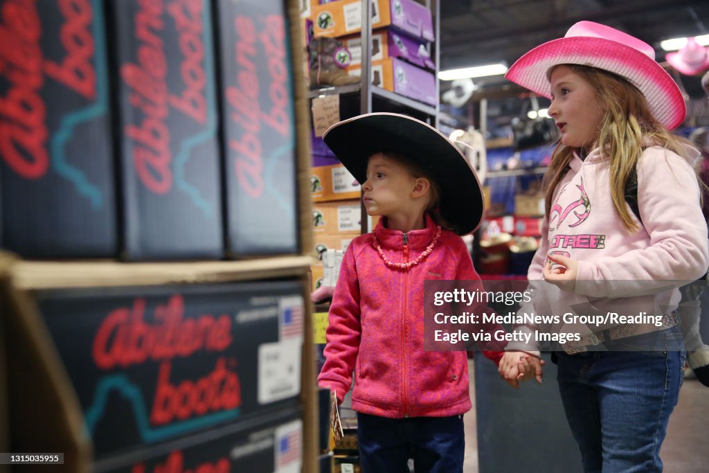 Cousins Lilly Fox, 4, of Palmerton, holds hands with Emily, 6, of Saylorsburg during the Pennsylvania Farm Show in Harrisburg on Jan. 13, 2015. Emily was shopping for a birthday present with her grandparents. Photo by Natalie Kolb 1/13/15