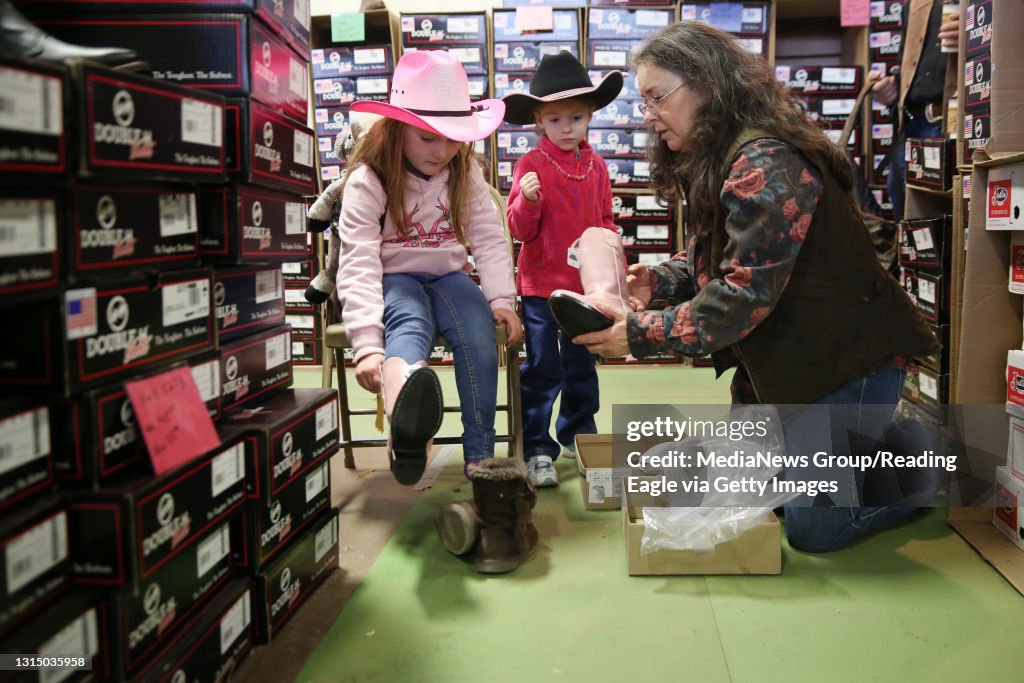 Emily Fox, 6, left, of Saylorsburg, tries on a pink pair of cowgirl boots with her cousin, Lilly, 4, of Palmerton, and her grandmother, Deb, of Bangor, during the Pennsylvania Farm Show in Harrisburg on Jan. 13, 2015. Photo by Natalie Kolb 1/13/15