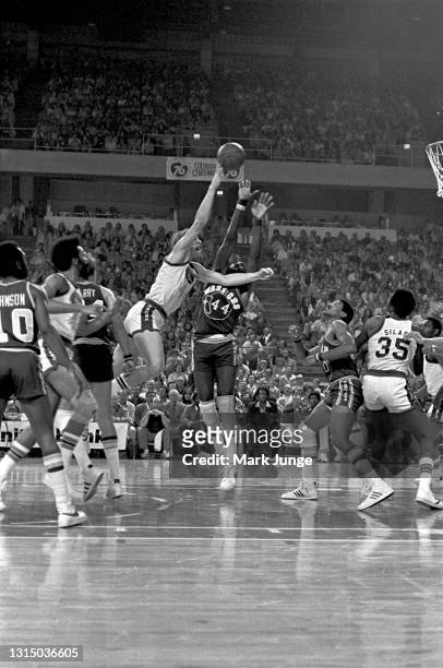 Denver Nuggets center Dan Issel shoots a running jumper over center Clifford Ray during an NBA basketball game against the Golden State Warriors at...