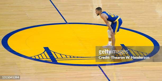 Stephen Curry of the Golden State Warriors stands at have court inside the logo and looks on against the Dallas Mavericks during the first half of an...