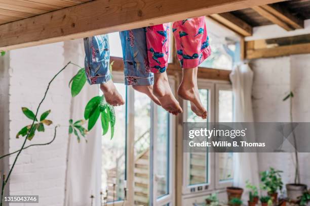 two pairs of legs dangling from mezzanine - mezzanine stockfoto's en -beelden