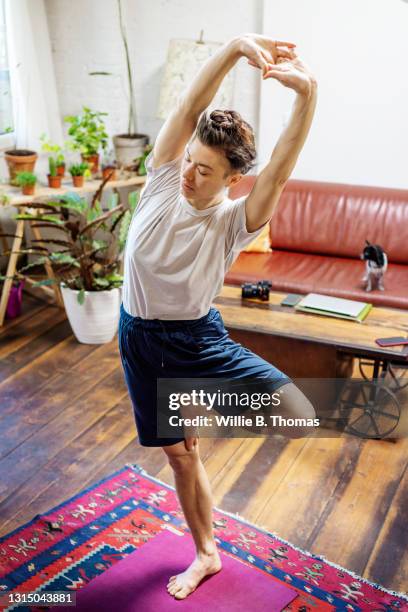 gay woman doing her morning stretches - yoga rug photos et images de collection