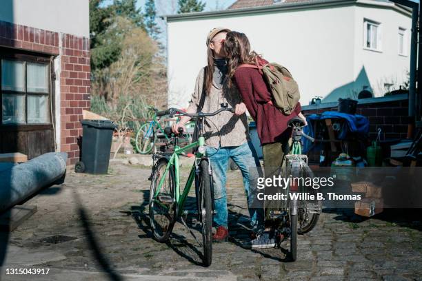 lesbian couple sharing kiss before going for bike ride together - vrouwen 32 jaar samen kus stockfoto's en -beelden