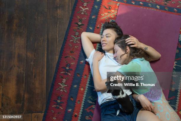 lesbian couple lying on floor together - lesbian dating 個照片及圖片檔