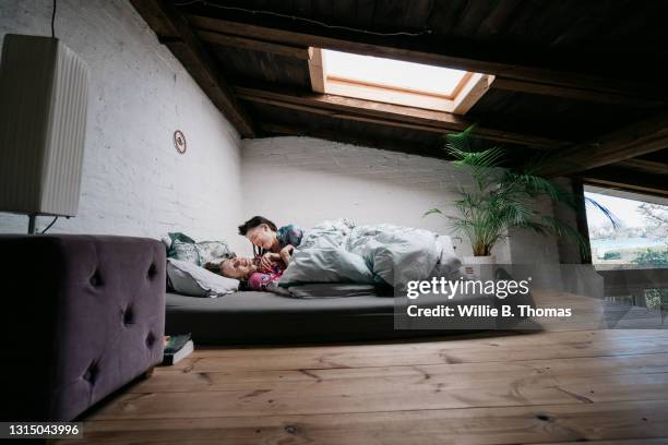 woman tickling her partner lying in bed - mezzanine stockfoto's en -beelden