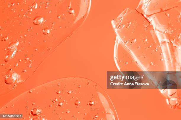 abstract texture of organic transparent gel with many air bubbles smudged on pastel orange monochrome background. concept of skin moisturizing or prevention covid-19 during pandemic. close-up and flat lay style with copy space - detox stock pictures, royalty-free photos & images