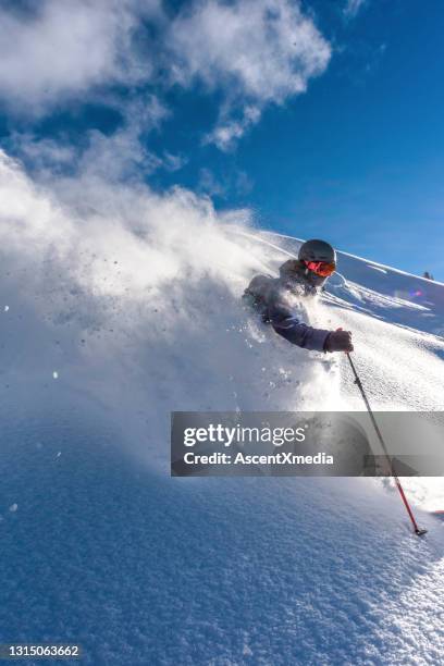 skiër daalt steile bergkam af door verse poedersneeuw - extreem skiën stockfoto's en -beelden
