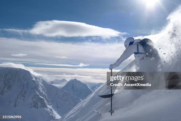 skier descends steep mountain ridge through fresh powder snow - frozen action stock pictures, royalty-free photos & images