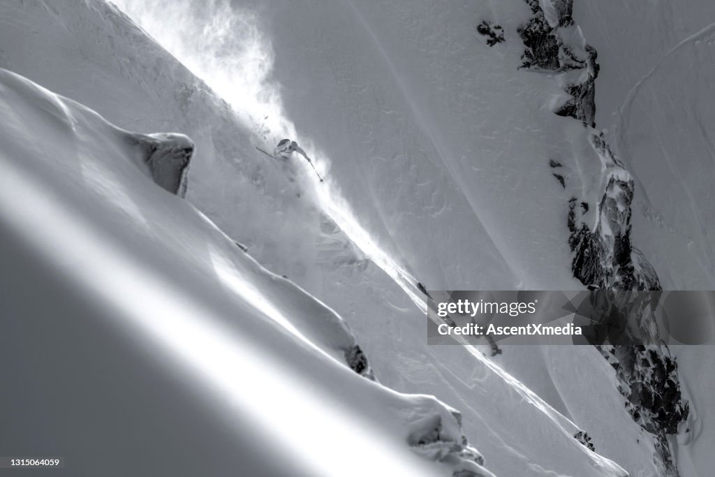 Skiër daalt steile bergkam af door verse poedersneeuw