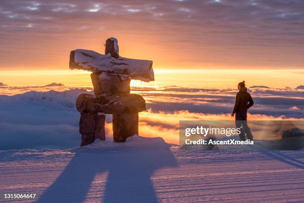 snowcapped mountains illuminated by morning light - inukshuk stock pictures, royalty-free photos & images