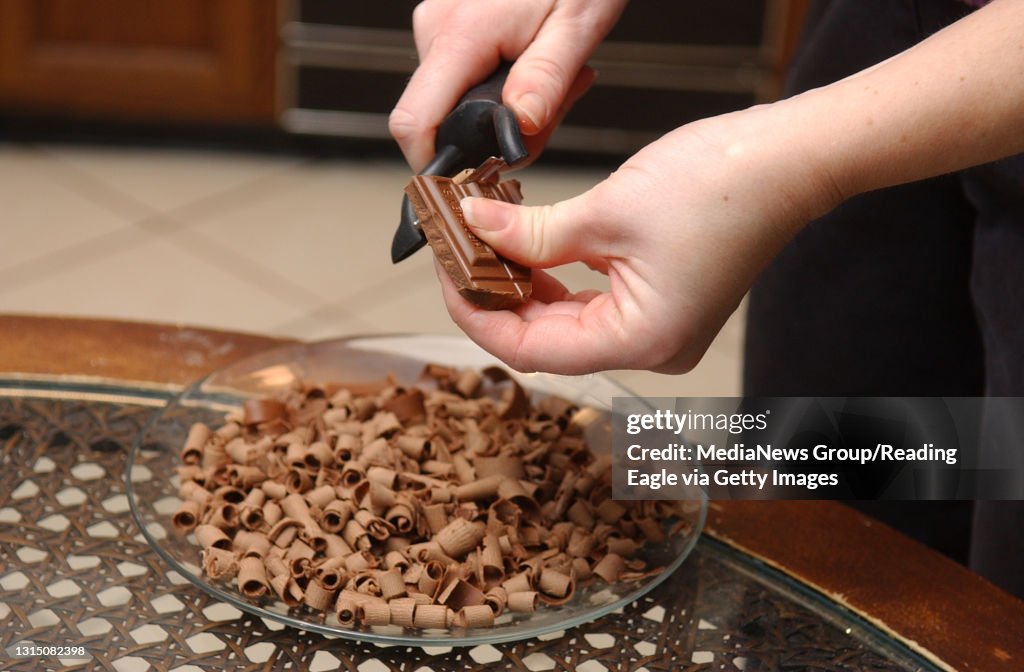 1/2/05 photo Ryan McFadden 200503376 Angela L Hausch of morgantown is making a Black Forest cake. SHE IS NOT MAKING THE SAME KIND OF CAKE THAT SHE WILL ENTER IN THE FARM SHOW! shaving chocolate from a hershey's bar for on top of the cake