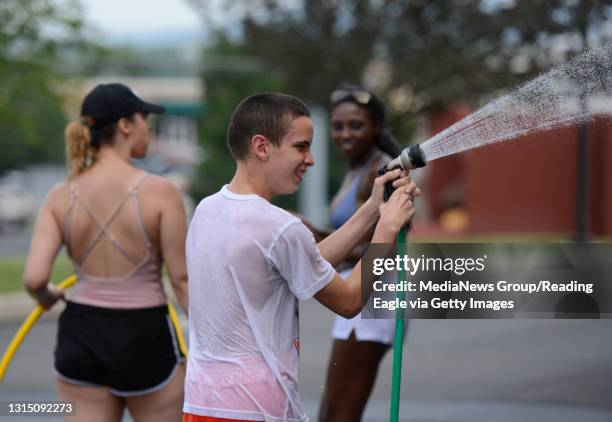 Seth gets a hold of the hose and starts pointing it at volunteers during a car wash fundraiser to support the purchase of a service dog for autistic...