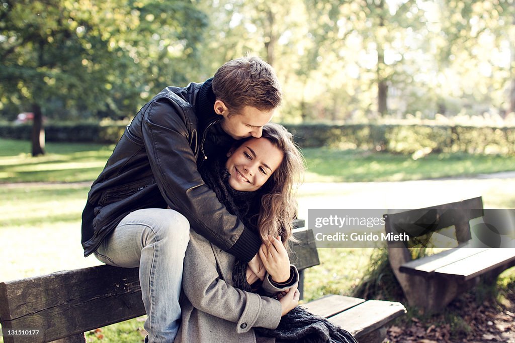 Young couple sitting on bench outdoor.