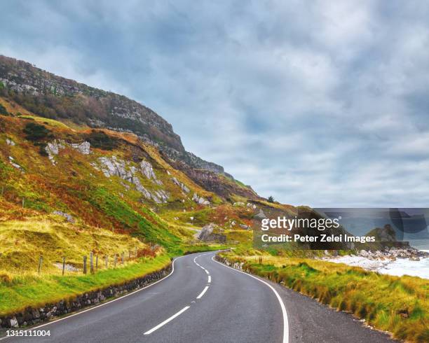 highway at the causeway coastline in northern ireland - costa caratteristica costiera foto e immagini stock