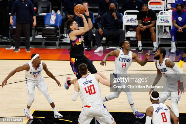 Devin Booker of the Phoenix Suns puts up a shot over Rajon Rondo, Ivica Zubac Terance Mann and Paul George of the LA Clippers during the second half...