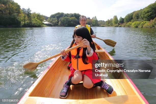 father canoeing with his daughter - family red canoe stock pictures, royalty-free photos & images