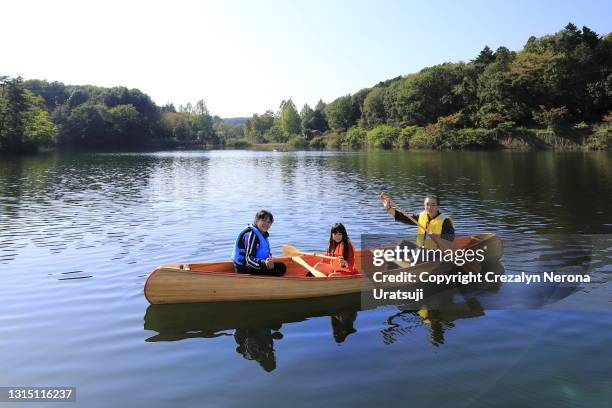 parents canoeing with their child - seniors canoeing stock pictures, royalty-free photos & images