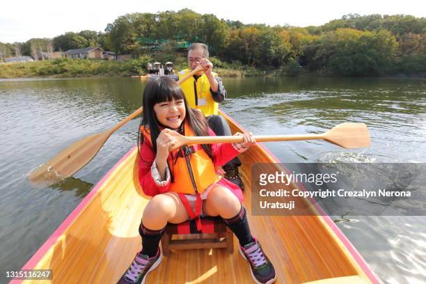 father canoeing with his daughter - family red canoe stock pictures, royalty-free photos & images