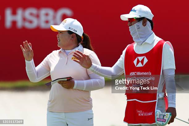 Inbee Park of South Korea and her caddie Gi Hyeob Nam react after completing the first round of the HSBC Women's World Championship at Sentosa Golf...