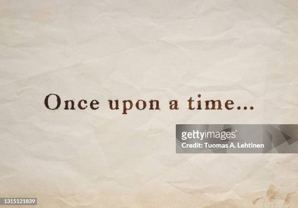 close-up of "once upon a time..." text on an old, stained and crumpled beige paper. - old book pages stock pictures, royalty-free photos & images