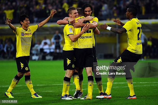 Sven Bender of Dortmund celebrates with Shinji Kagawa and other team mates after scoring his teams thirg goal during the Bundesliga match between...