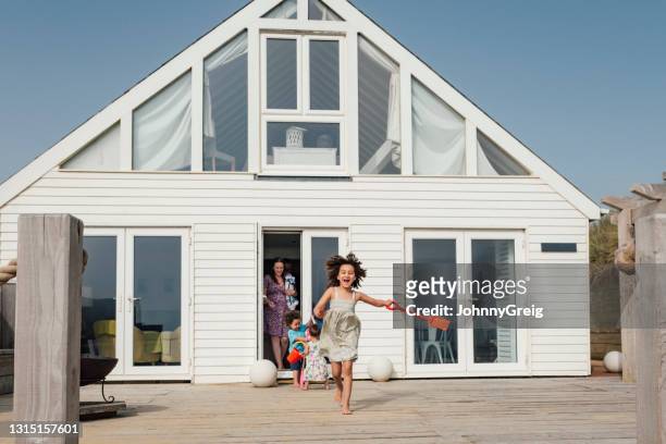 gemengd ras elementair leeftijdsmeisje dat familie naar het strand leidt - vakantiehuis stockfoto's en -beelden