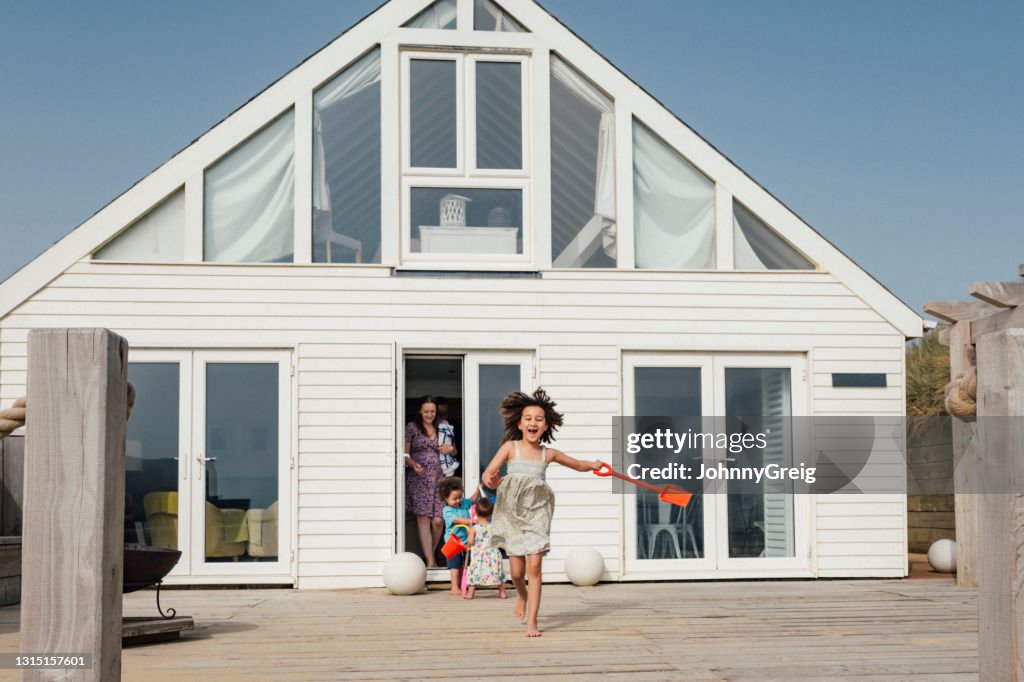 Mixed race elementary age girl leading family to the beach