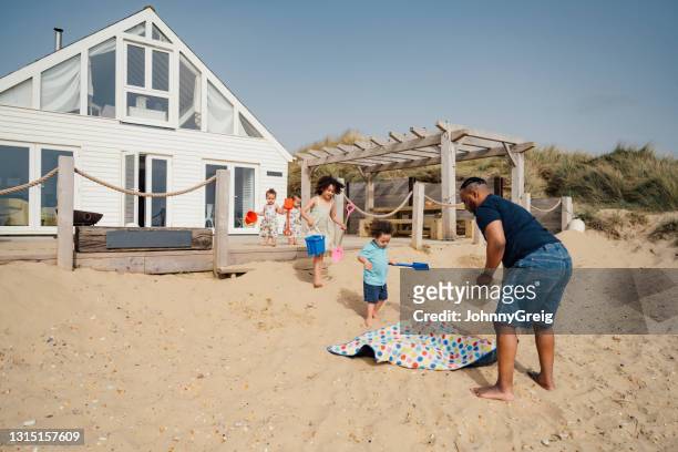 ビーチで一日の準備をしている4人の子供を持つ父親 - camber sands ストックフォトと画像