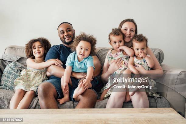informeel portret van diverse jonge familie thuis - down syndrome baby stockfoto's en -beelden
