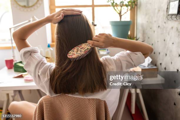 giovane donna con pettinatura i suoi bellissimi capelli castani - spazzola per capelli foto e immagini stock