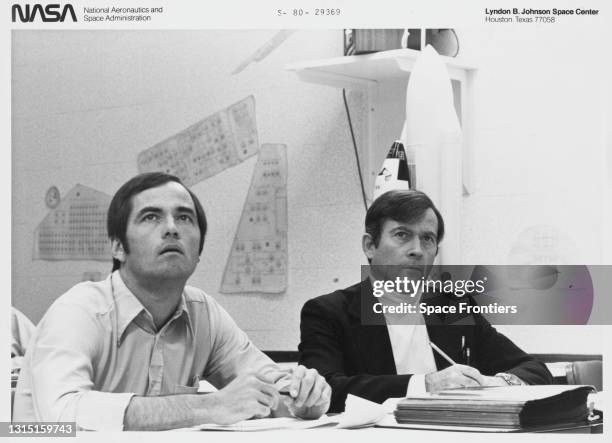 Astronauts John W Young , STS-1 prime crew commander, and Robert L Crippen taking notes during a briefing following their 'Columbia' Space Shuttle...