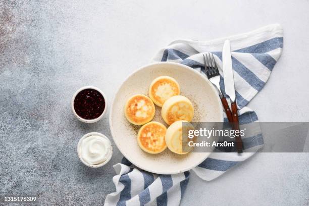 cottage cheese fritters served with fruit jam and sour cream - cheese jam stock-fotos und bilder