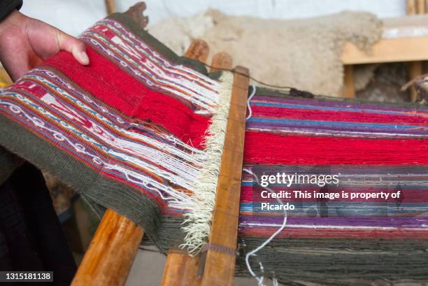 closeup of some colorful fabrics made by local peruvian women using an old loom at chinchero in sacred valley area, peru. fabrics made of llama wool. - vicuna wool stock pictures, royalty-free photos & images