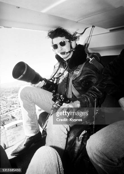 photographer kypros with telephoto lenses and camera equipment in helicopter above los angeles - usa, 1990 - helicopter photos stock pictures, royalty-free photos & images