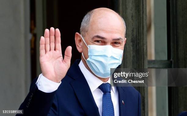 Slovenia's Prime Minister Janez Jansa wearing a protective face mask waves to media prior to a working lunch with French President Emmanuel Macron at...