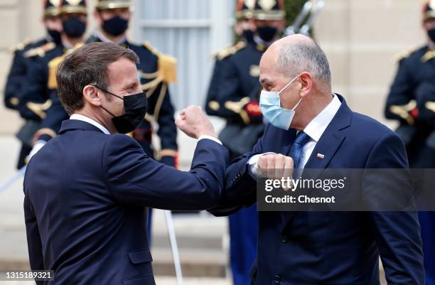 French President Emmanuel Macron wearing a protective face mask bumps elbows with Slovenia's Prime Minister Janez Jansa prior to a working lunch at...