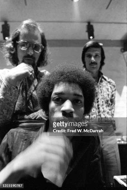 Close-up of American musician Jimi Hendrix , South African-born American music producer and engineer Eddie Kramer and studio manager Jim Marron as...