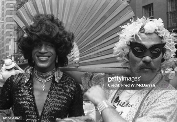 View of American gay liberation activist Marsha P Johnson during the Pride March , New York, June 27, 1982. The masked marcher at right is...