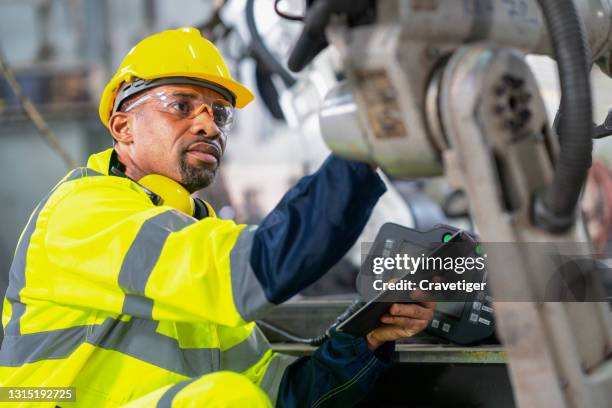 senior inspector working in robot factory . he check the robot before work in process. - system failure stock pictures, royalty-free photos & images