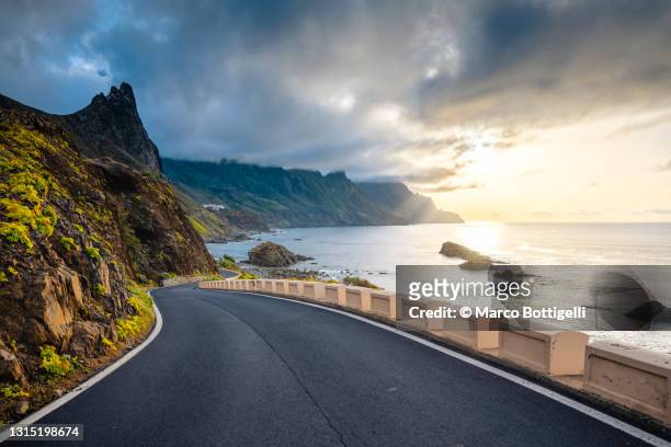 scenic coastal road at sunset - sunset road stock-fotos und bilder