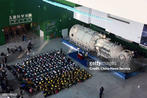 Visitors look at a life-size model of 'Tianhe', the core module of China's first space station, at China Science and Technology Museum on April 29,...