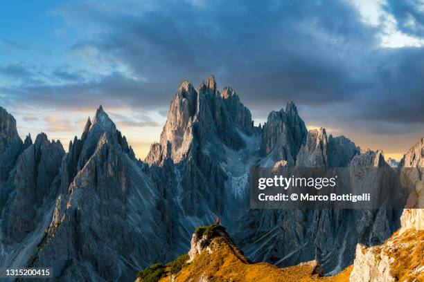 one person standing on top of a mountain ridge in the dolomites, italy - dolomites stock pictures, royalty-free photos & images