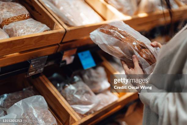 young woman shopping bread in supermarket - bread packet stock pictures, royalty-free photos & images
