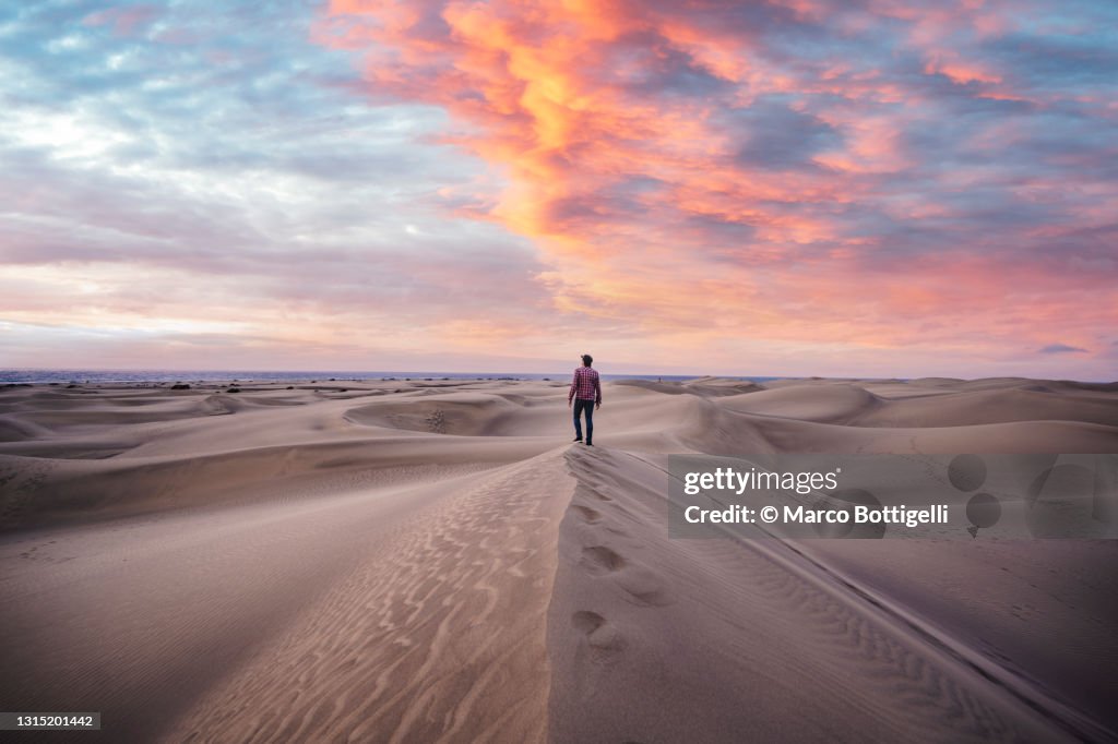 One man standing on top of a sand dune at sunrise, Grand Canary, Spain
