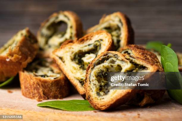 homemade spinach and cheese triangle pie slices on a table - spinach pie stock pictures, royalty-free photos & images