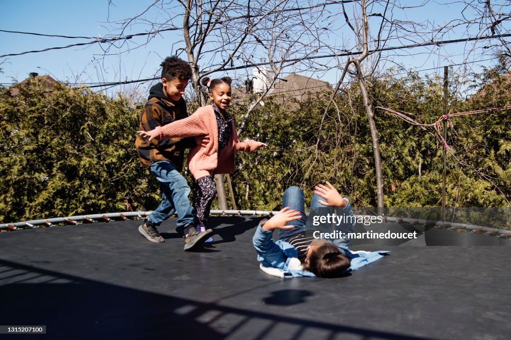 Fratelli che saltano sul trampolino all'aperto in primavera.