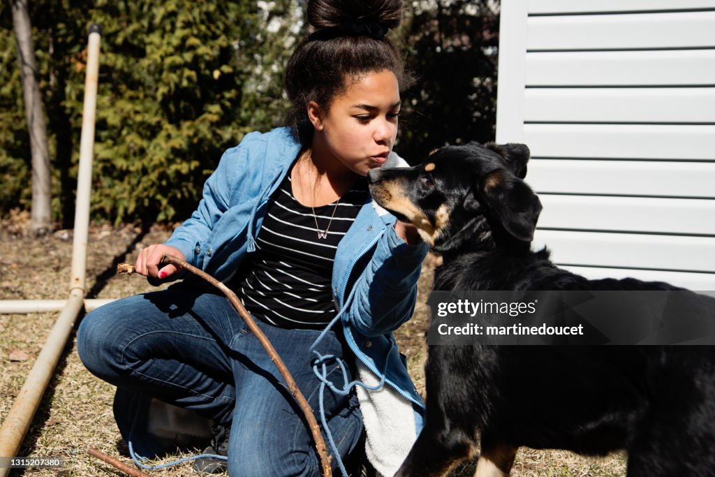 Preteen meisje spelen met hond buitenshuis in de lente.