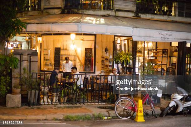 people outside of bar and restaurant in vientiane at night - vientiane stock pictures, royalty-free photos & images
