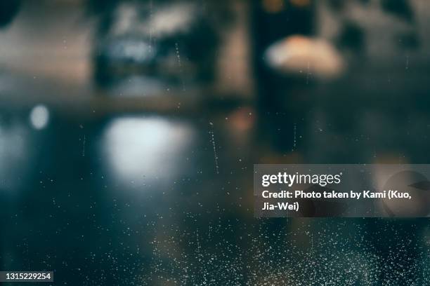raindrops on glass with bokeh background at night. - window stockfoto's en -beelden