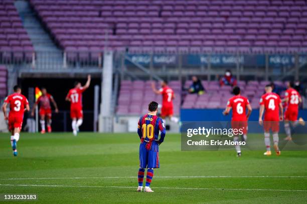 Lionel Messi of FC Barcelona looks dejected as Darwin Machis of Granada CF celebrates with teammates after scoring their team's first goal during the...